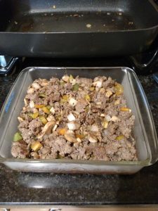 meat and vegetables added to glass baking dish
