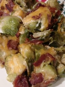cheesy brussels sprouts with bacon pieces on top