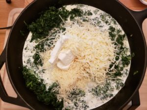 cooking spinach, cream and cheeses in skillet