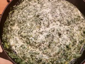 Creamy Spinach Cheese Bake in cast iron skillet while cooking