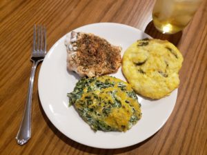 Creamy Spinach Cheese Bake on plate with biscuit and fish