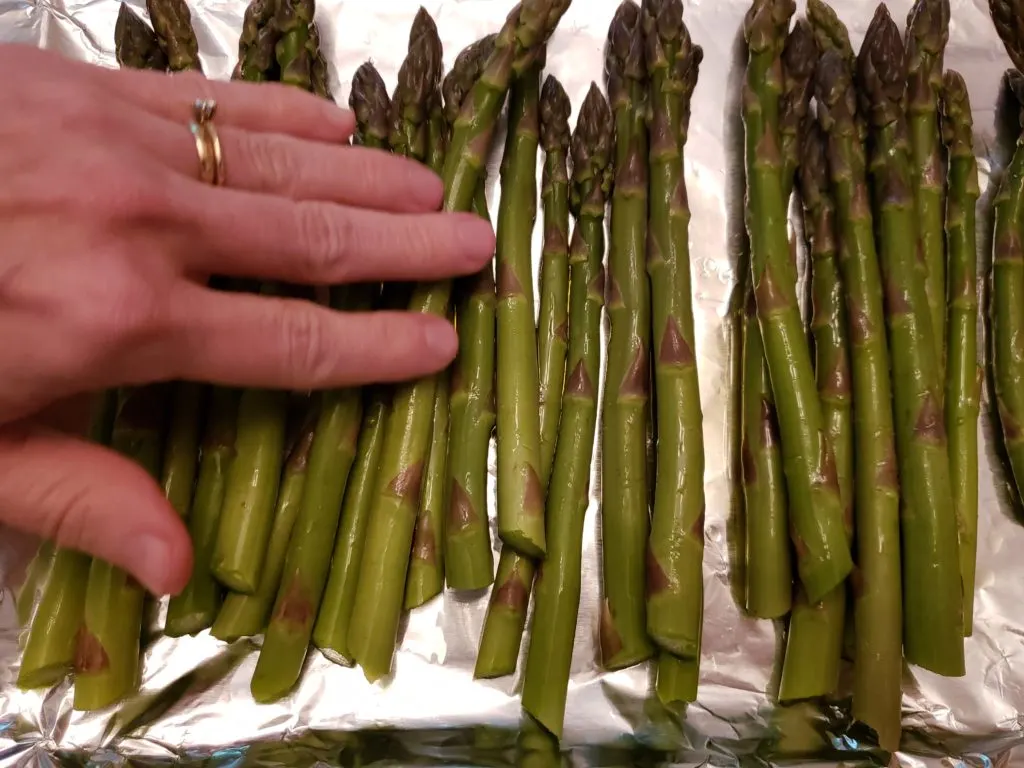 rubbing olive oil onto asparagus