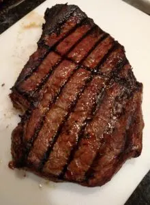 Grilled Marinated London Broil beautifully grilled on a white plate