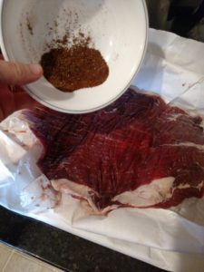 dumping seasonings on steak