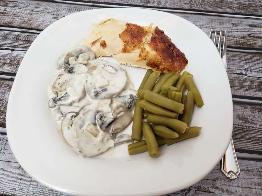 Creamed Mushrooms, rotisserie chicken and green beans on white plate
