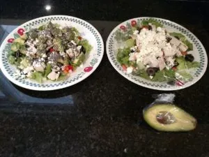 2 plates of Mediterranean Garden Salad with a wrapped avocado in front of one.