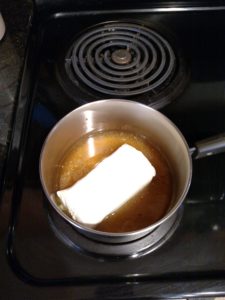 block of cream cheese in sauce pan with broth