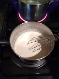 stirring the sauce in a saucepan on stove
