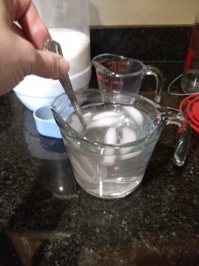 mixing hummingbird food and ice cubes.