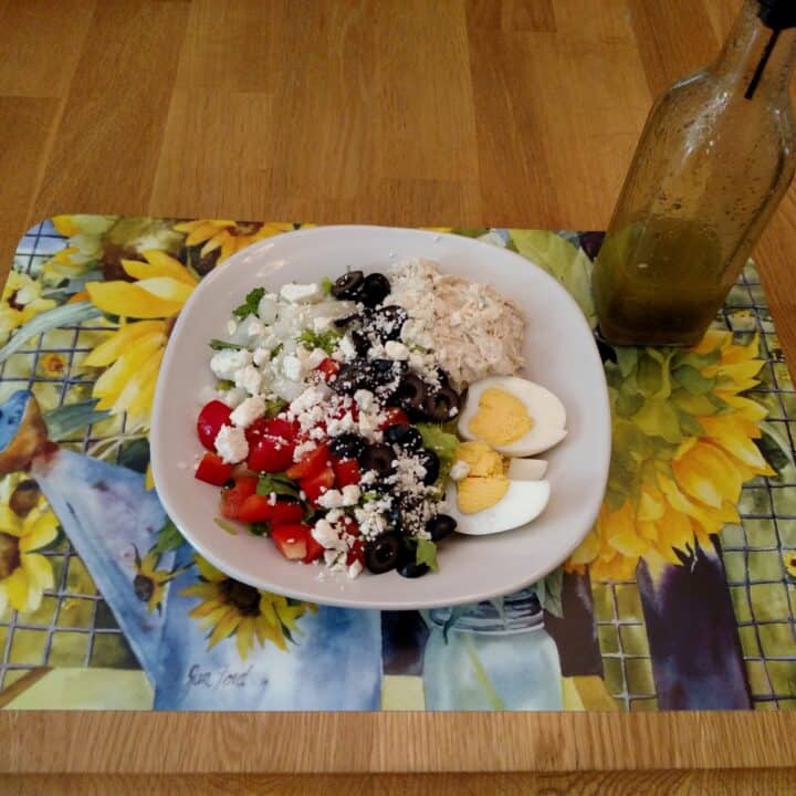 Homemade Italian Dressing Dry Mix on a salad pictured on a pretty sunflower mat