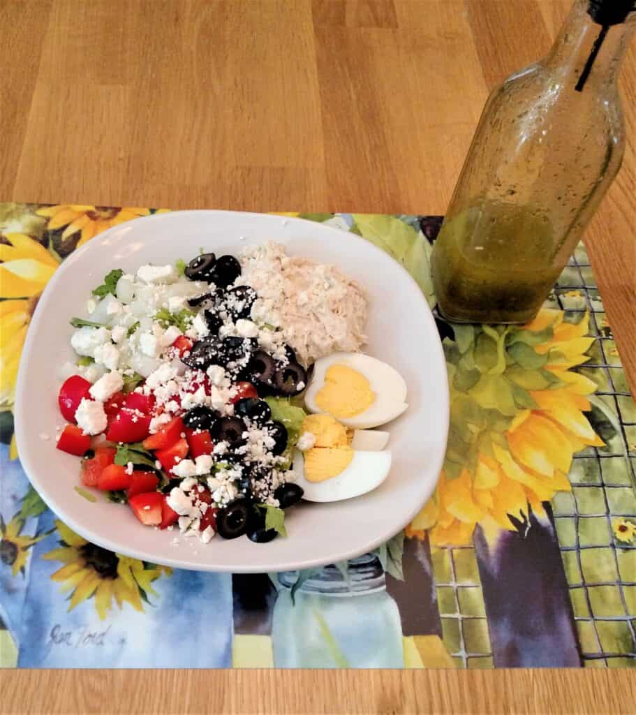 Homemade Italian Dressing Dry Mix on a salad pictured on a pretty sunflower mat