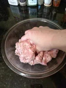 mixing meat and seasonings with hand