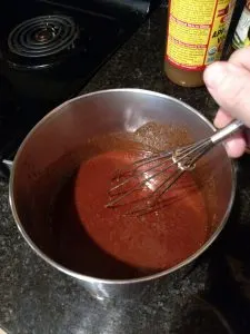 stirring Low Carb No Sugar Homemade BBQ Sauce in saucepan