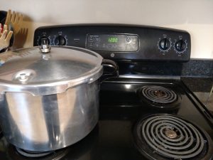 canner sitting on stove that is all turned off to cool down and let the pressure drop.