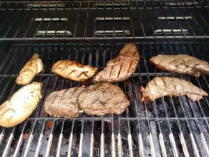 steaks and chicken on the grill