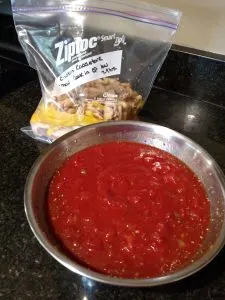 chicken and vegetables in Ziploc bag and tomato sauce and seasonings in bowl