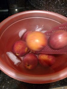 peaches in bowl of ice water.