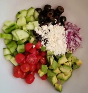 Ingredients for Greek Cucumber Avocado Salad in a bowl