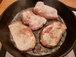 4 pork chops in skillet