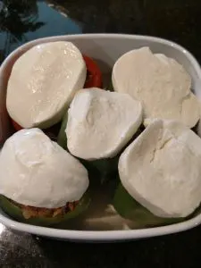 mozzarella cheese on top of peppers in baking dish