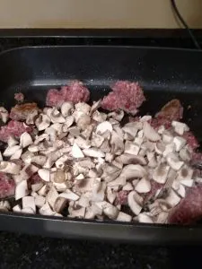 meat and mushrooms cooking in electric skillet