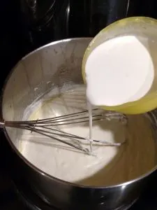process shot for  Easy Homemade Alfredo Sauce; stirring in the heavy cream