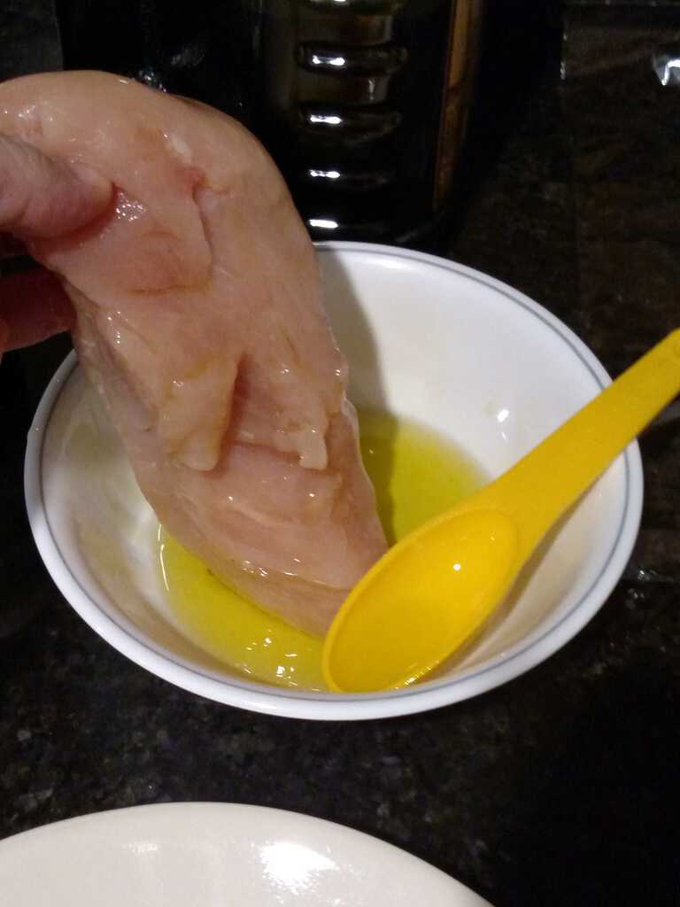 dipping chicken into olive oil