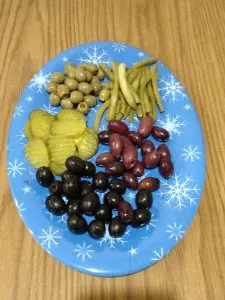 different olives and pickles on blue plate