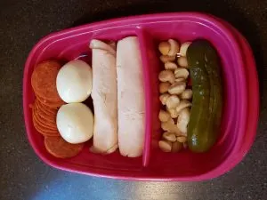 Pepperoni, hard boiled egg, lunchmeat chicken, cheese and mustard rolled up, pickle and macadamia nuts