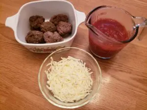 bowls with meatballs, shredded cheese and spaghetti sauce