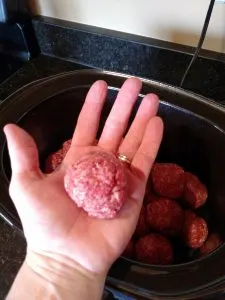 One 3 Ingredient Keto Crock Pot Meatball in hand to show size