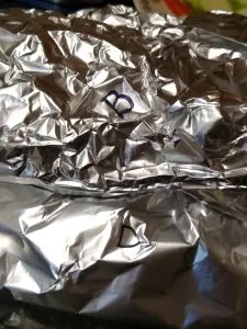 pile of Keto Meat and Vegetable Foil Packets with initials on them