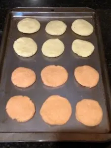 6 each of yellow and orange cookies on baking sheet.