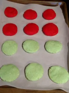 6 each of red and green cookie on baking sheet.