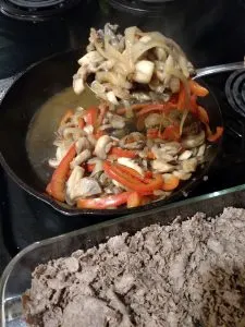 adding cooked vegetables on top of meat