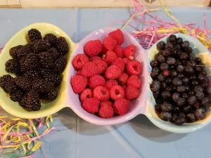black, raspberries and blueberries in easter dish