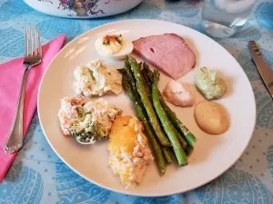 Easter meal on pretty blue tablecloth with Easter eggs on it