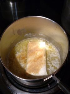 cream cheese and garlic powder added to melted butter in saucepan