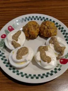4 lazy deviled egg halves and 2 low carb gluten free sausage balls on a plate