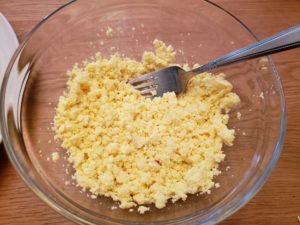 yolks in a bowl being mashed with a fork