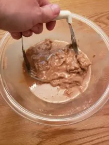 stirring peanut butter in glass bowl