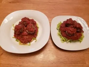 2 plates of Keto Zoodles with Meatballs and Marinara Sauce before cheese is added