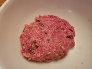 raw hamburger ingredients in a bowl