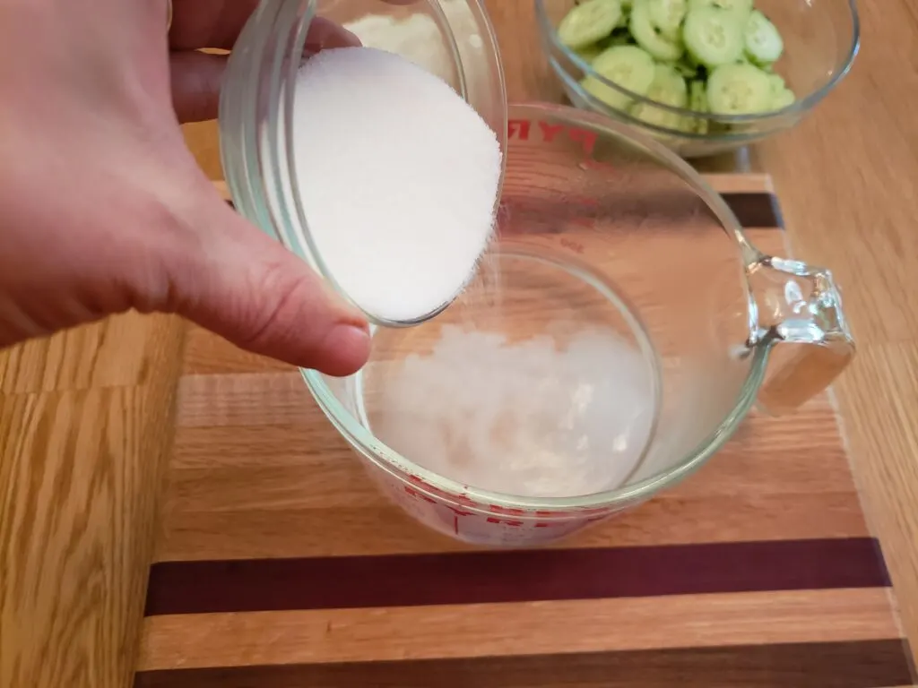 adding sweetener to measuring cup