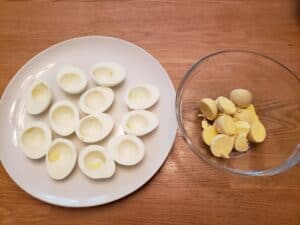 egg white halves on plate and yolks in a bowl