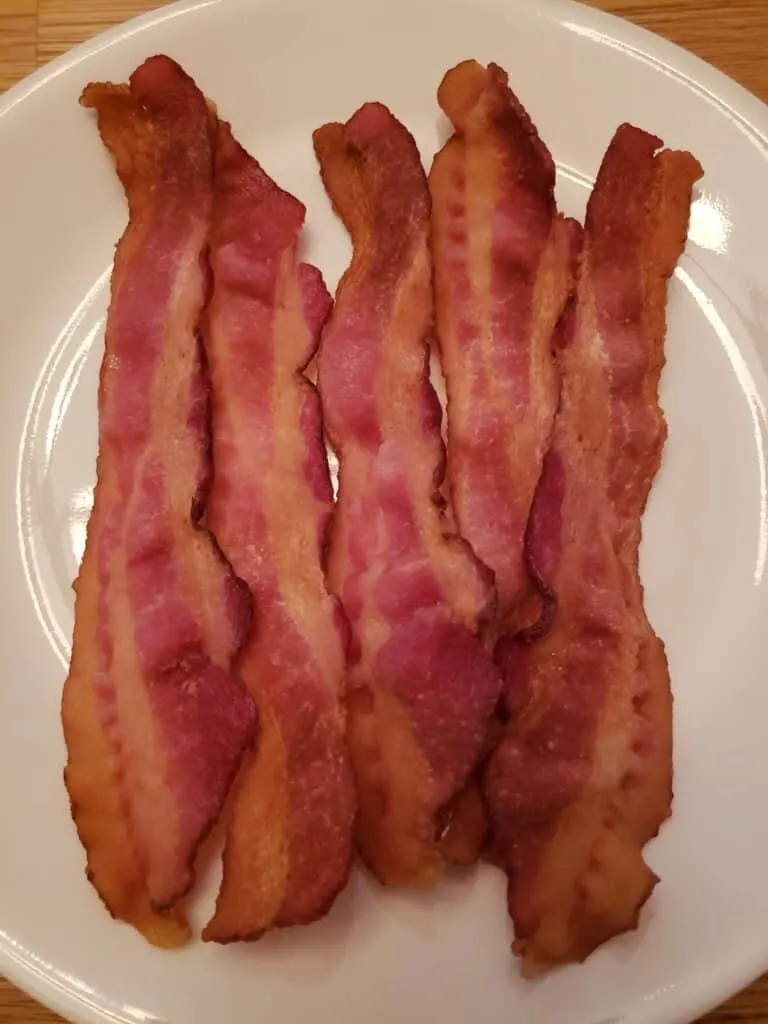 5 slices of bacon on a white plate