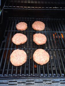 Low Carb BBQ Cheddar Burgers raw on the grill