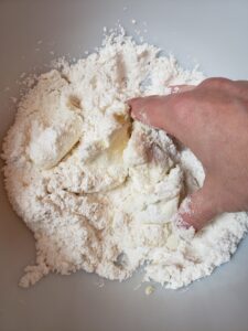 mixing together sugar and cream cheese