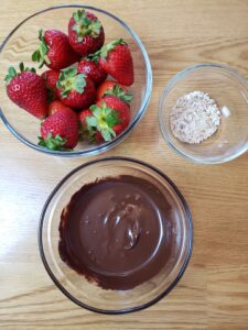 3 glass bowls with strawberries, melted chocolate and chopped walnuts