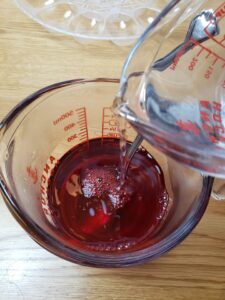 pouring water into red jello